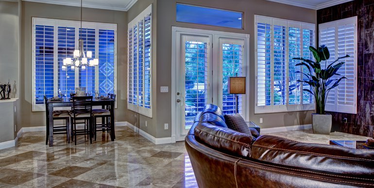 Charlotte great room with plantation shutters and tile floor.